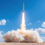 Rocket launch with smoke and clouds in background, showcasing power and technology