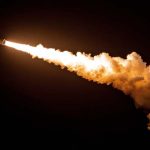 A rocket ascends into the dark sky, igniting fiery exhaust as it breaks through billowing clouds. The launch showcases human innovation and determination in space exploration.